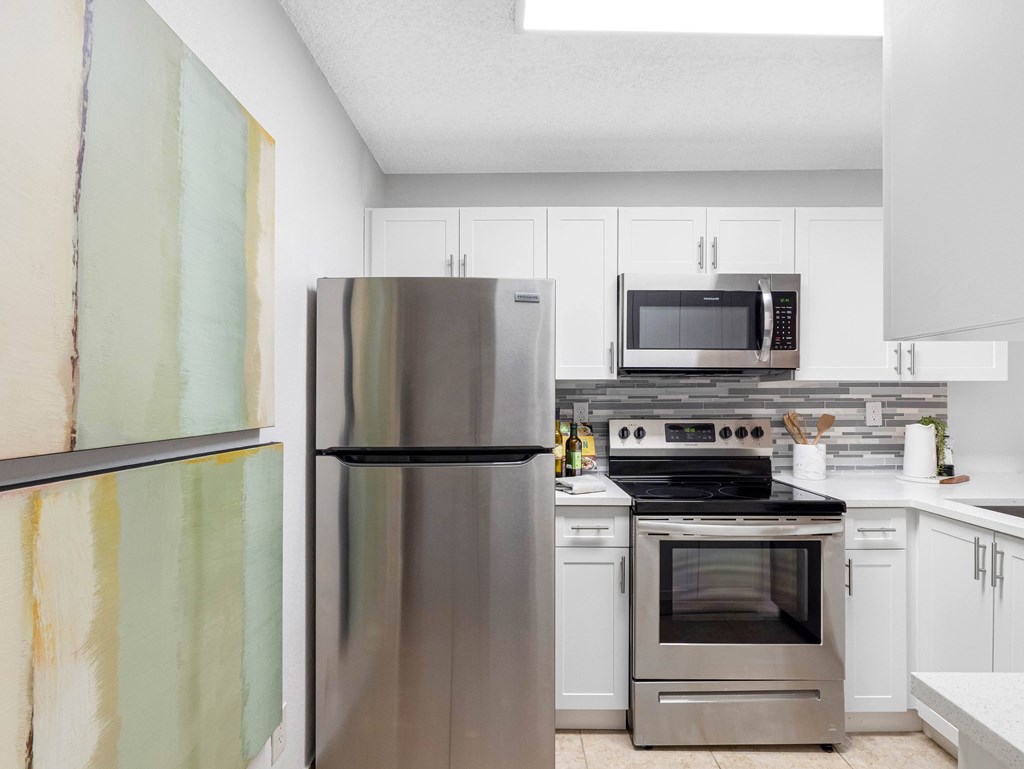 A modern kitchen with a stainless steel refrigerator and microwave.